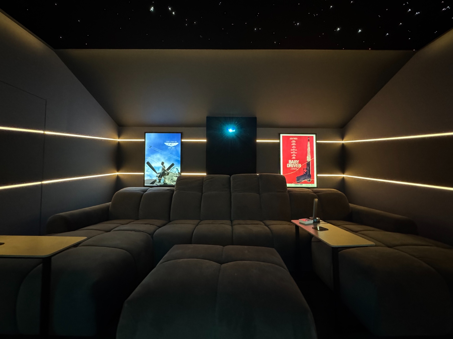 Cinema room rear view with star ceiling, film posters and projector